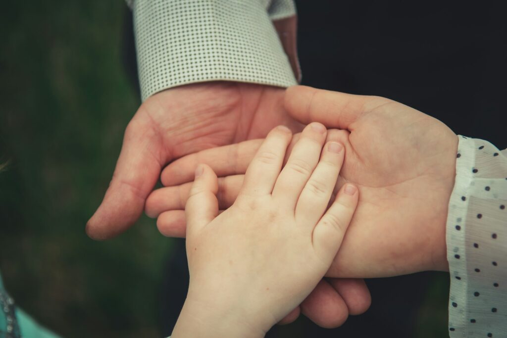 A close-up of a family holding hands, symbolizing unity and togetherness.